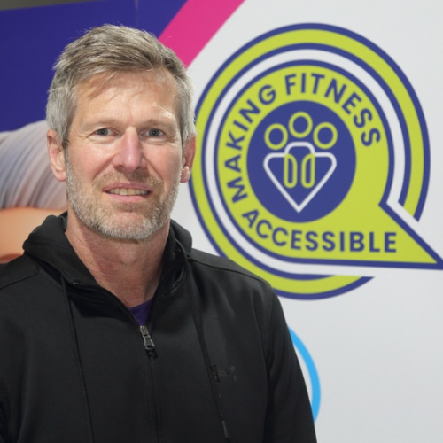 Alan Pearson, Centre Manager at The Angel Centre and founder of HealthWorkz, in front of Making Fitness Accessible logo